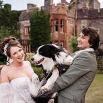 A bride and groom with their dog in front of Ruthin Castle